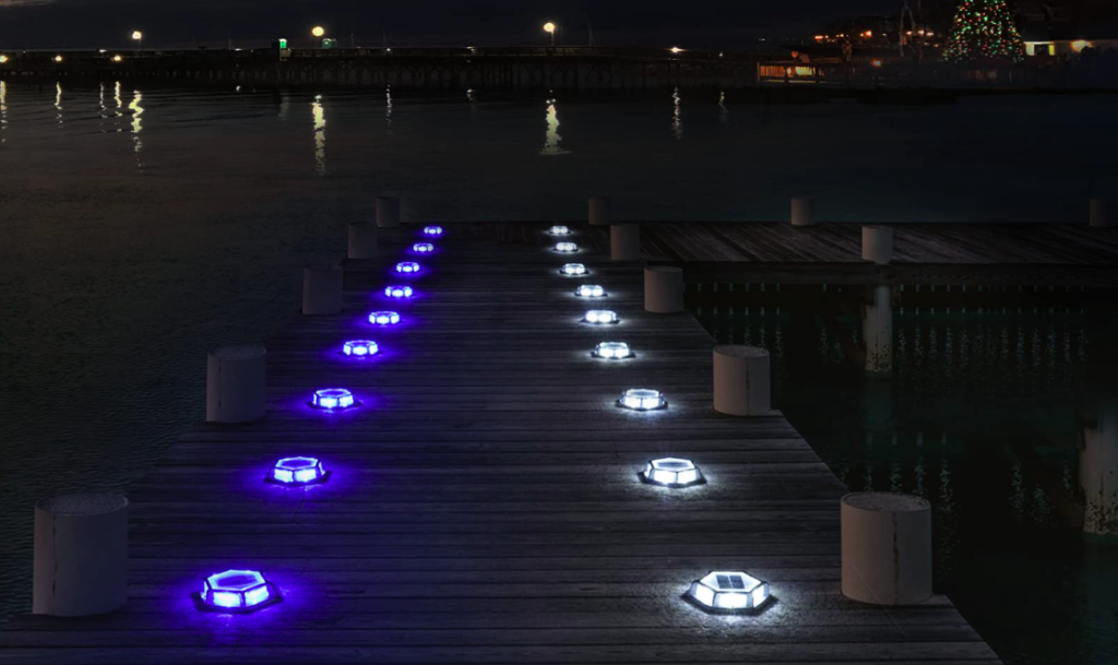 Floor-mounted lights illuminate a waterfront boat dock.
